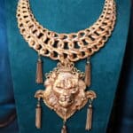 A necklace with a lion head and tassels on it.