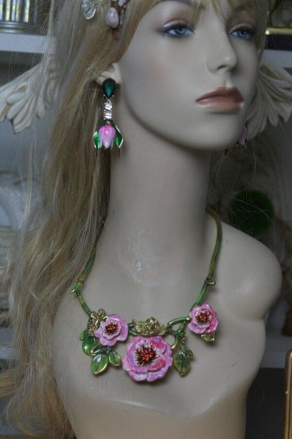 A mannequin wearing a necklace and earrings.