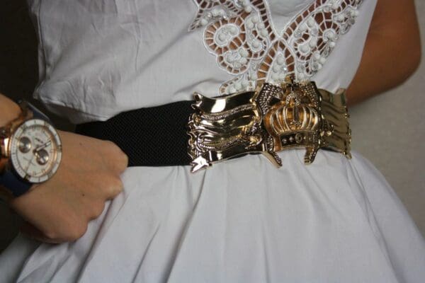 A woman is holding onto the belt of her dress.