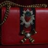A red purse with a strawberry on it.