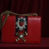 A red purse with a bow and ribbon on it.