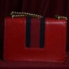 A red purse with black stripe on the front.
