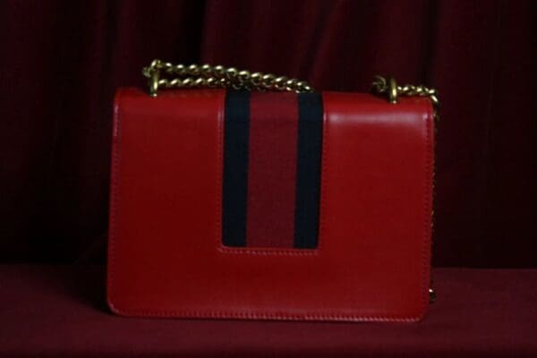 A red purse with black stripe on the front.
