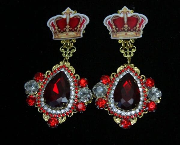 A pair of earrings with red and white stones.