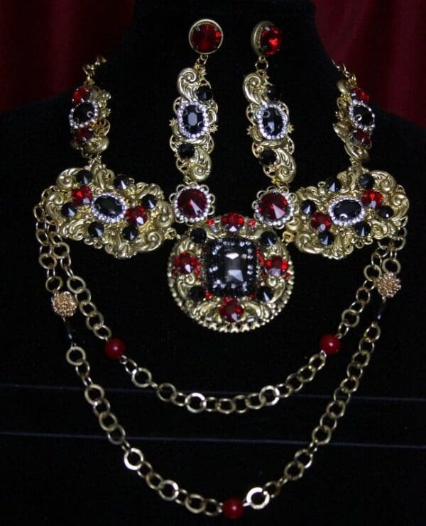 A necklace and earrings set with red, blue and yellow stones.