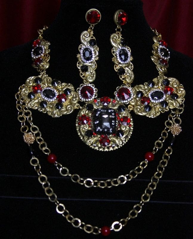 A necklace and earrings set with red, blue and yellow stones.