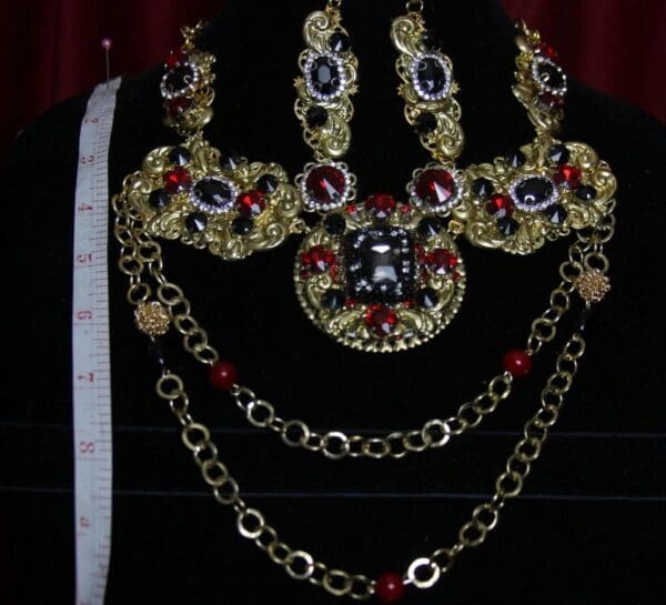 A necklace and earrings set with gold, red and blue stones.