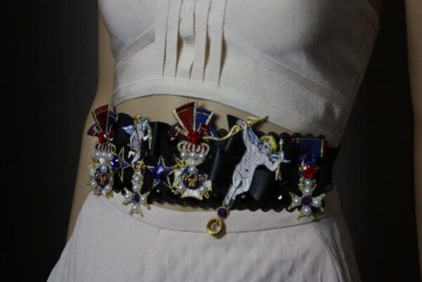 A woman wearing a white dress with a belt around her waist.