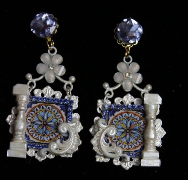 A pair of earrings with a clock and flowers.