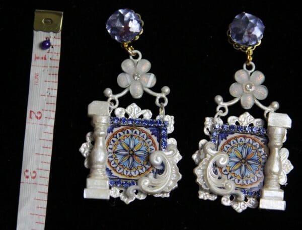 A pair of earrings with blue and white designs.