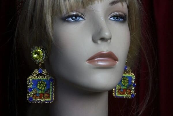 A mannequin wearing earrings with blue and yellow designs.