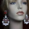 A mannequin wearing earrings with a picture of jesus.