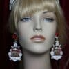 A mannequin wearing earrings with red beads.