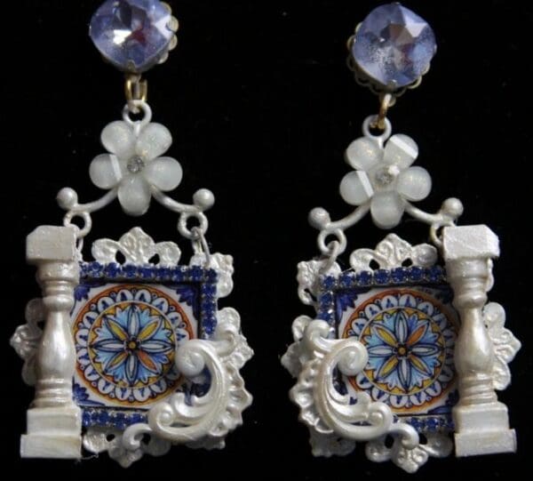 A pair of earrings with blue and white designs.