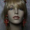 A mannequin head wearing red earrings and a headband.