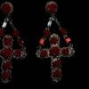A pair of red earrings with crosses hanging from them.