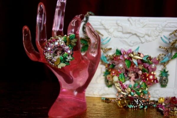 A pink hand with many different jewels in it