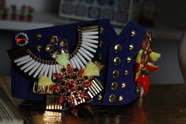 A blue purse with some gold and red accents