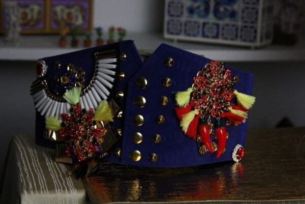 A pair of blue and red earrings sitting on top of a table.