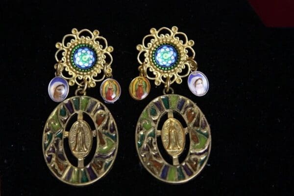 A pair of earrings with religious images on them.