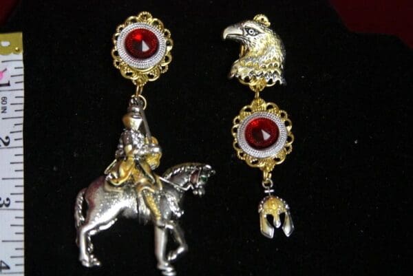 A pair of earrings with a horse and rider.