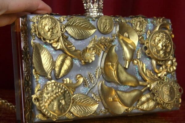 A woman holding onto a silver and gold purse