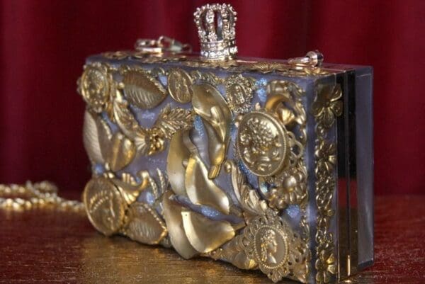 A gold and silver box with some ornaments on it