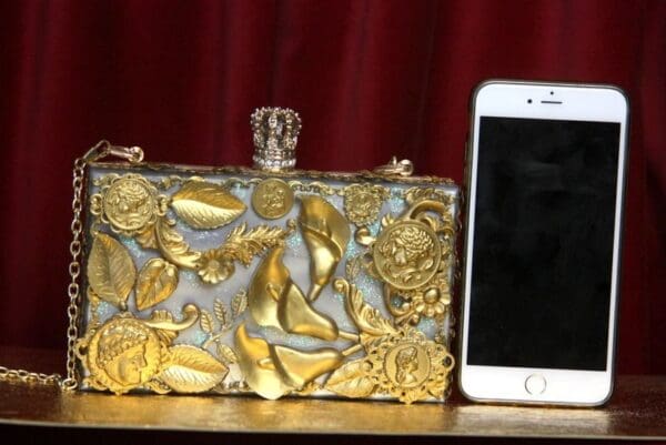 A cell phone and a purse on a table.