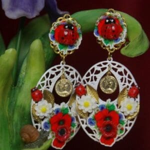 A pair of earrings with flowers and faces on them.