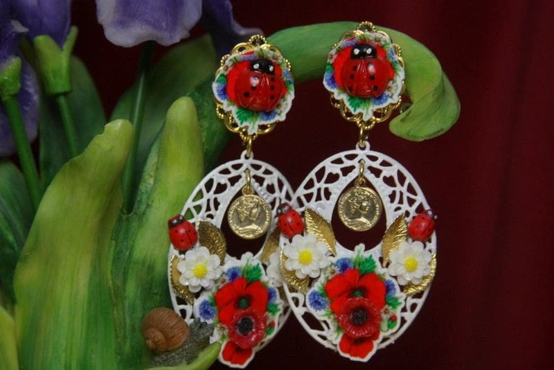 A pair of earrings with flowers and faces on them.