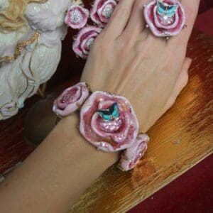 A woman 's hand with some pink and white flowers on it