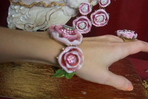 A woman wearing a bracelet with pink flowers.