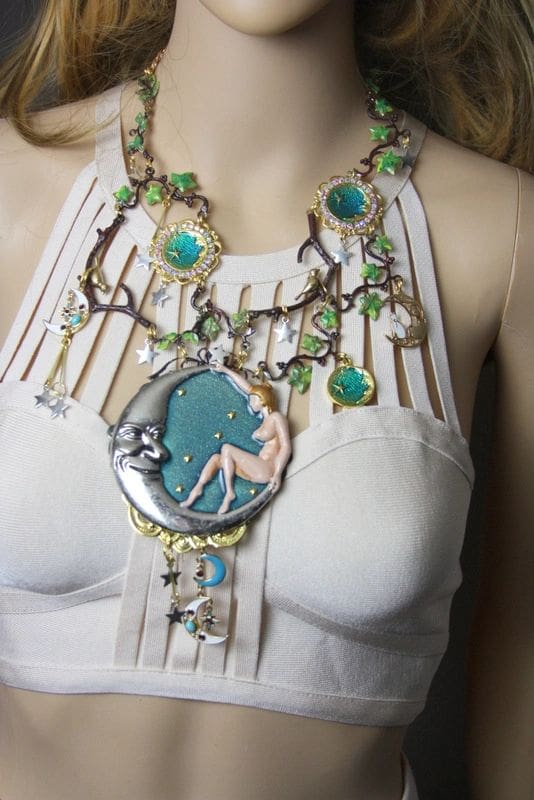 A woman wearing a necklace with green beads and white lace.