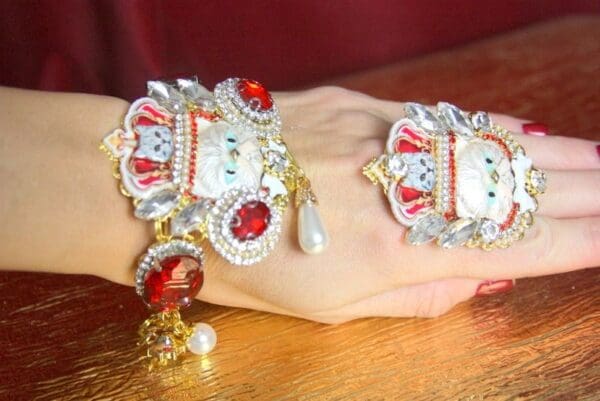 A hand wearing jewelry on top of it.