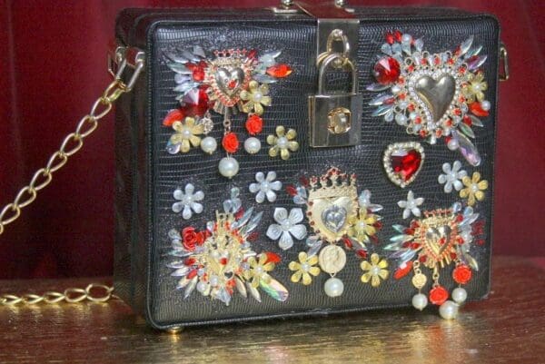 A black purse with some colorful embellishments on it