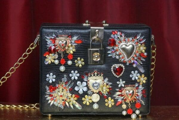 A black purse with many different designs on it.