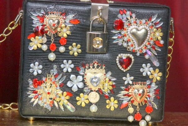 A black purse with many different colored jewels on it.