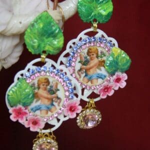A pair of earrings with a picture and flowers.