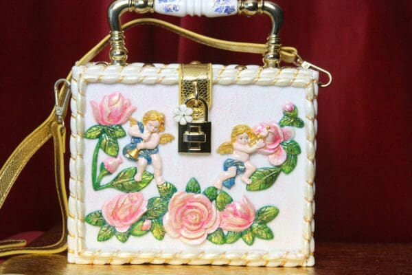 A white box bag with pink flowers and angels.