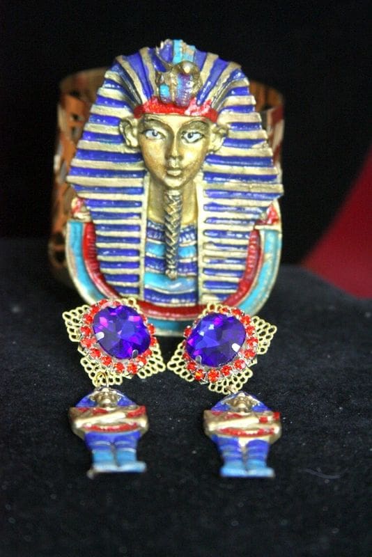 A statue of an egyptian pharaoh with blue and red jewels.