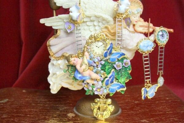 A statue of an angel with blue flowers and gold chains.