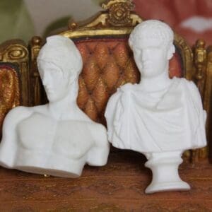 Two white statues sitting on top of a table.