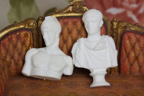 Two white statues sitting on top of a table.