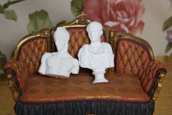 Two white busts sitting on a couch