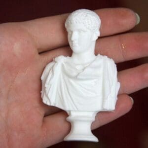 A person holding a white statue in their hand.