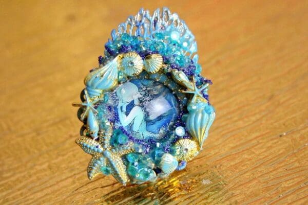 A blue and white ring with some shells on it