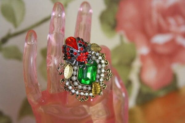 A hand with a ring on it and some pearls