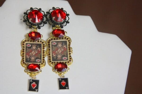 A pair of earrings with red stones and a black frame.