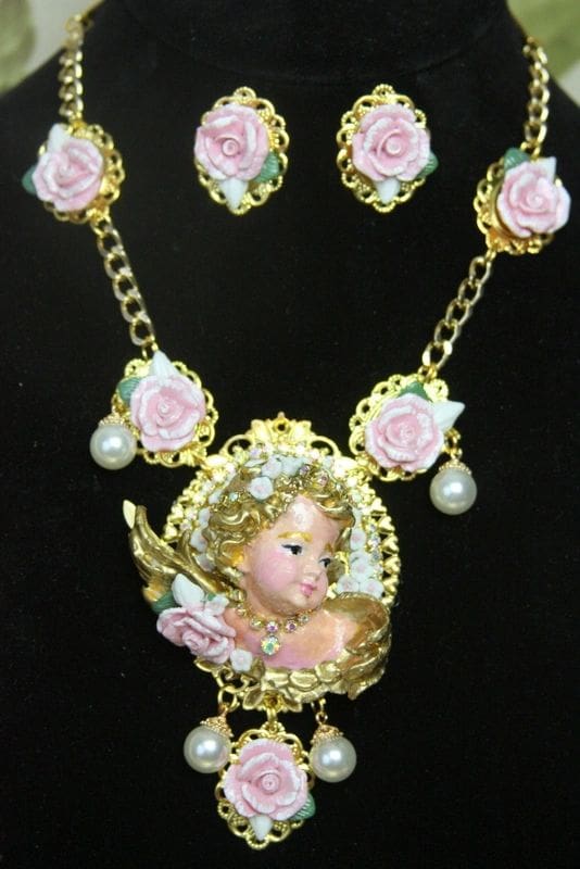 A necklace and earrings set with pink roses.