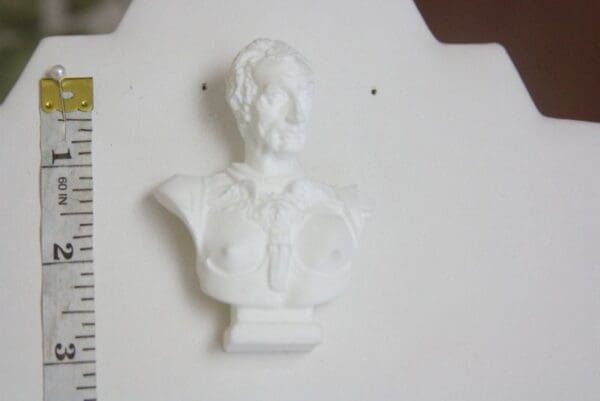 A white bust of a woman on top of a table.